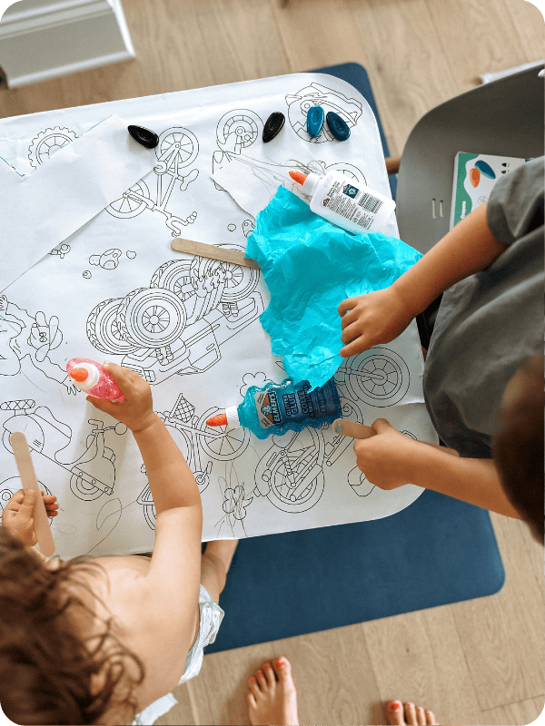 kids using giant coloring sheets on lalo play table