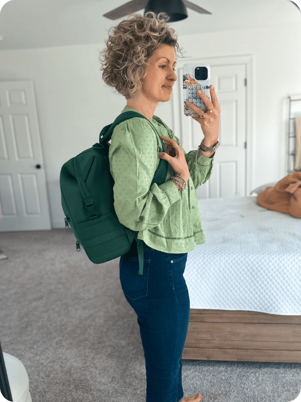mom carrying the Dagne Dover Diaper Bag in green