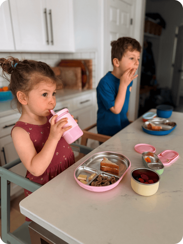 two children eating off of Lalo stainless steel plates 