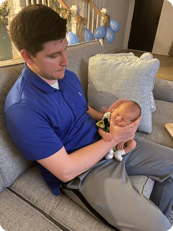 Dad burps newborn in the upright burp position, being sure to support baby's head and neck.