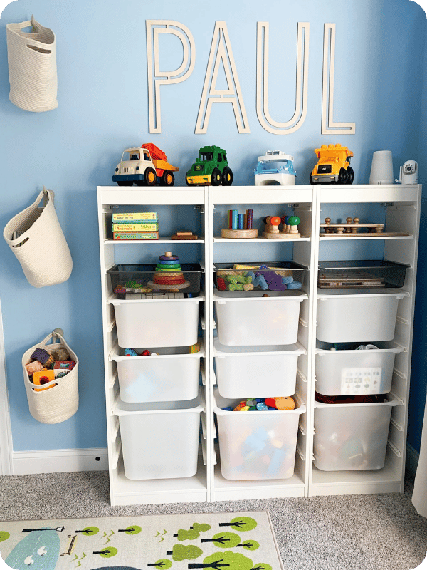 Blue wall in toddler's room with an organizer cabinet and baskets hung on the wall, keeping toys organized and ready to grab