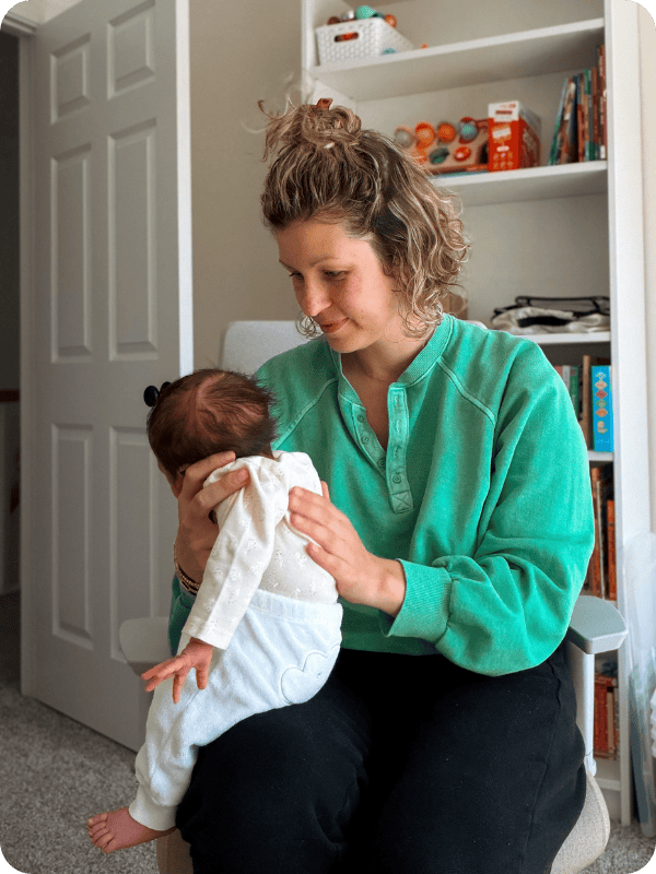Mom burps newborn baby using the upright position, careful to support baby's head and neck.