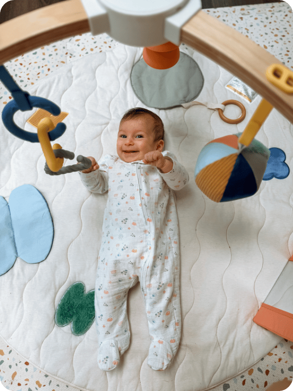 3 month old plays on the Lalo Play Gym II during a wake window