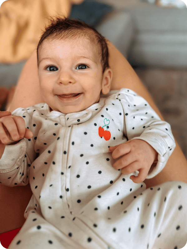 Baby smiles at the camera during wake window play time