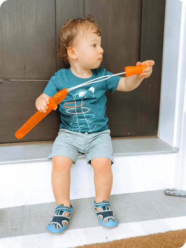 toddler boy playing with bubble wand