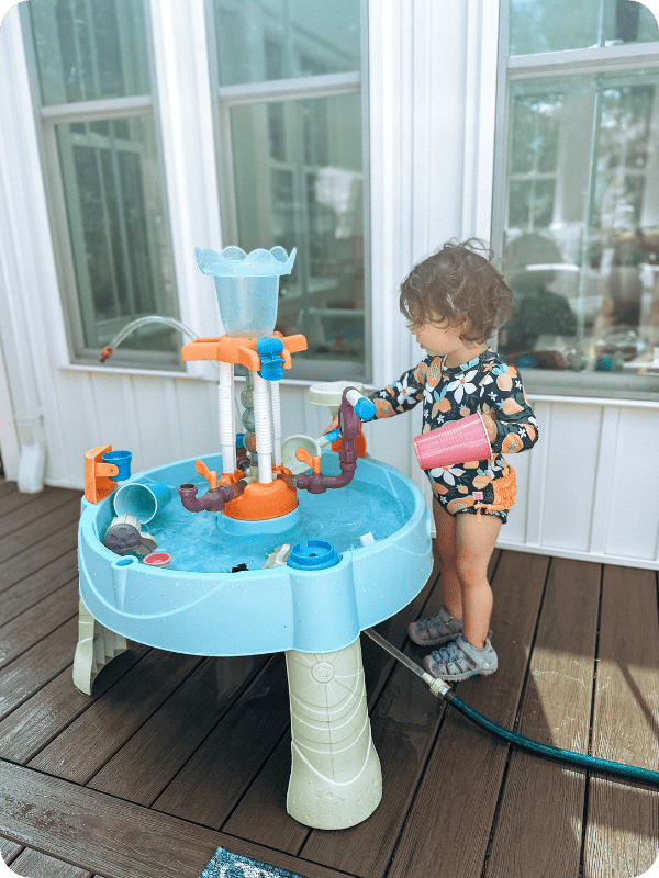 toddler playing at water table 