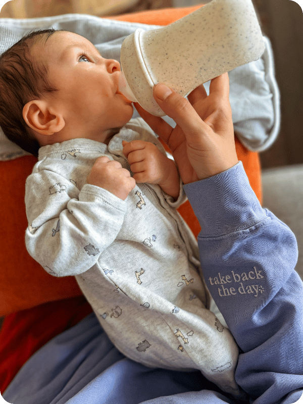 Newborn takes a bottle in an elevated side-lying position.