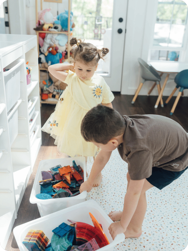 Brother and sister toddlers play with magnetic tiles