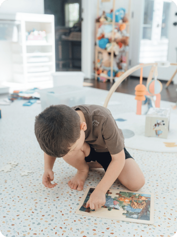 Preschooler plays with a puzzle on the floor