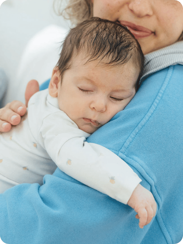 Newborn sleeping on their mom's shoulder.