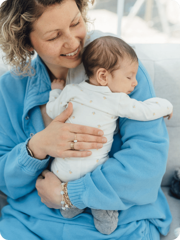 Mom holds her newborn up against her shoulder, patting baby's back gently.