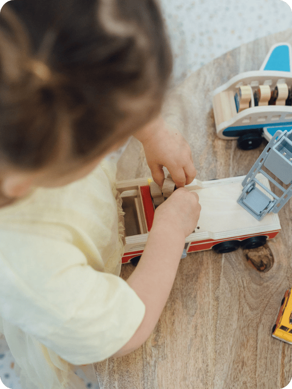 Toddler plays with a wooden firetruck toy