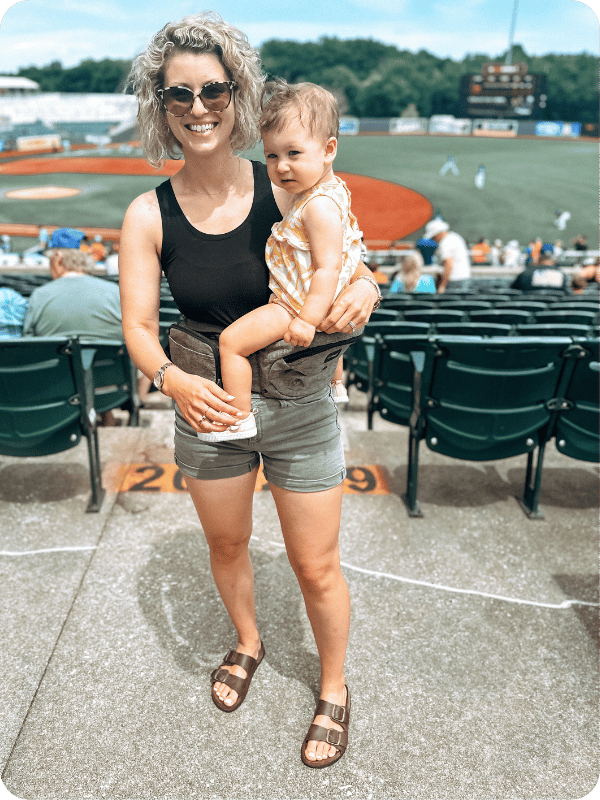 mom using tush baby hip carrier with baby 