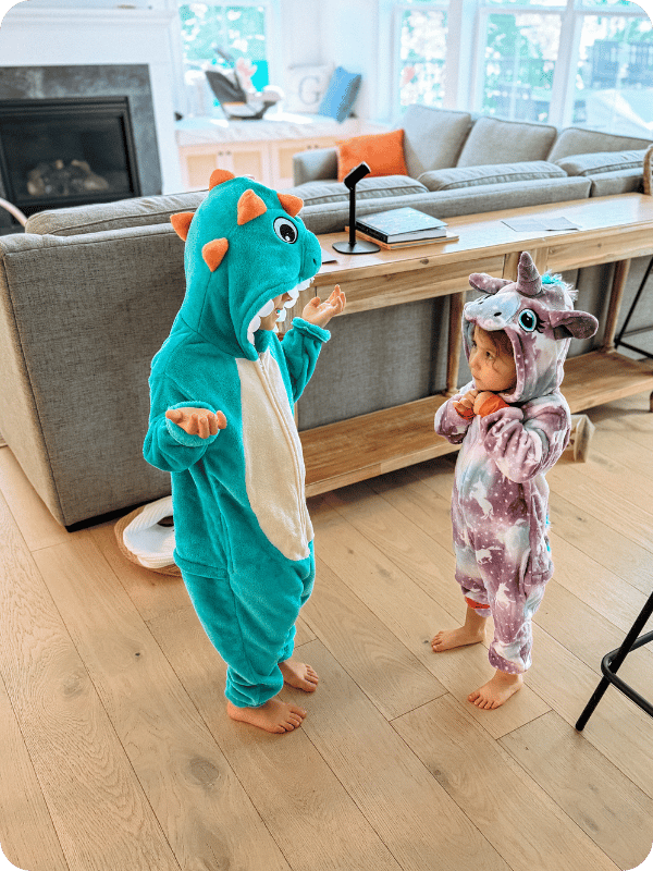 toddlers in dress up dinosaur and unicorn outfits playing pretend 