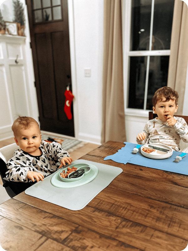 baby and toddler eating dinner wearing bibs