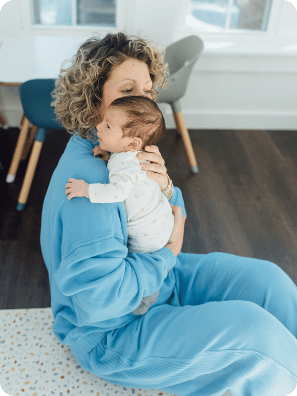 Mom holds young infant upright against her shoulder, so baby can see the world from a new angle.