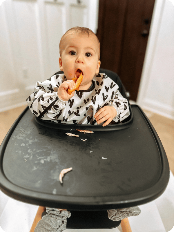 Infant practices self-feeding skills in the high chair