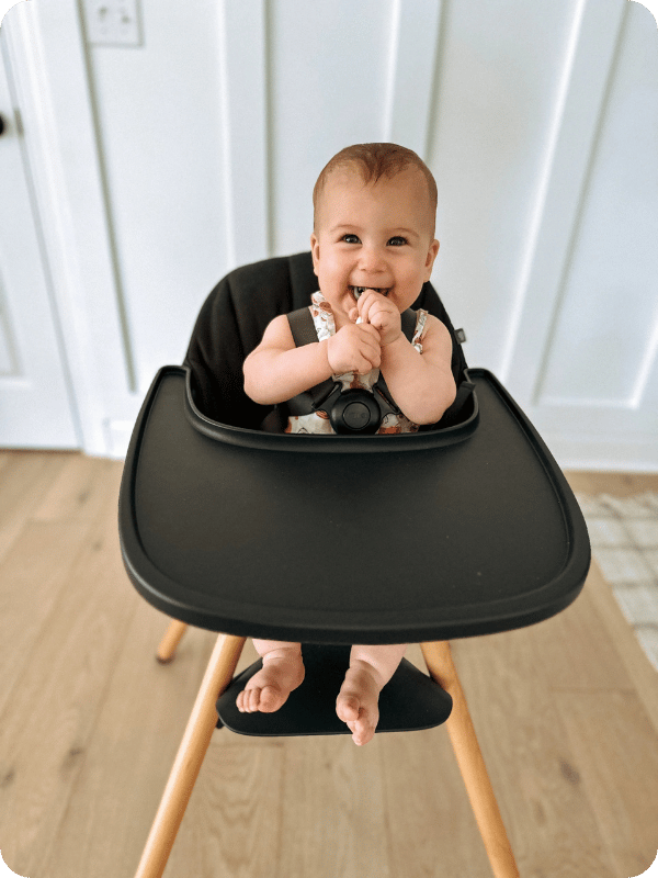 Baby smiles in her high chair.