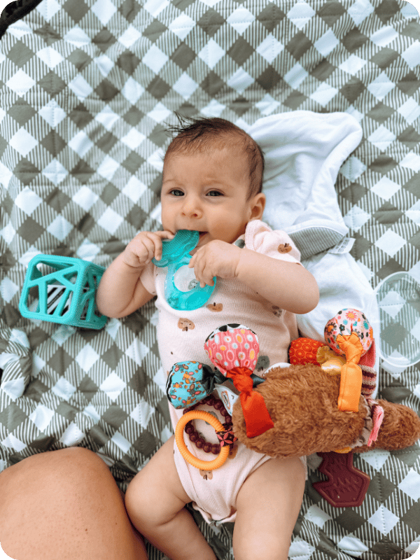 3 month old baby plays with her first teether.