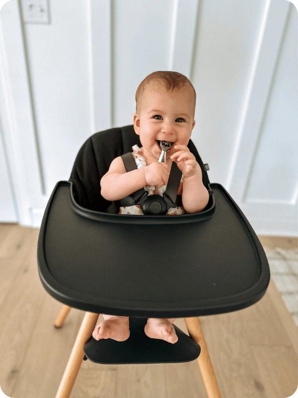 Baby sits in the high chair, fully supported and ready to start solids.