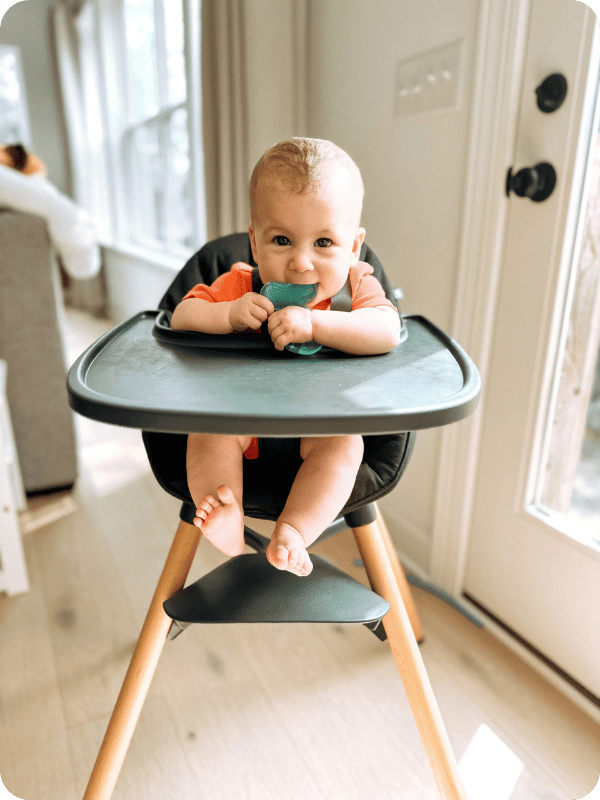 This baby is not ready to start solids because she is hunching in the chair and using her elbows for support.