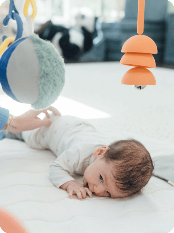 Newborn does tummy time on the Lalo Play Gym II.