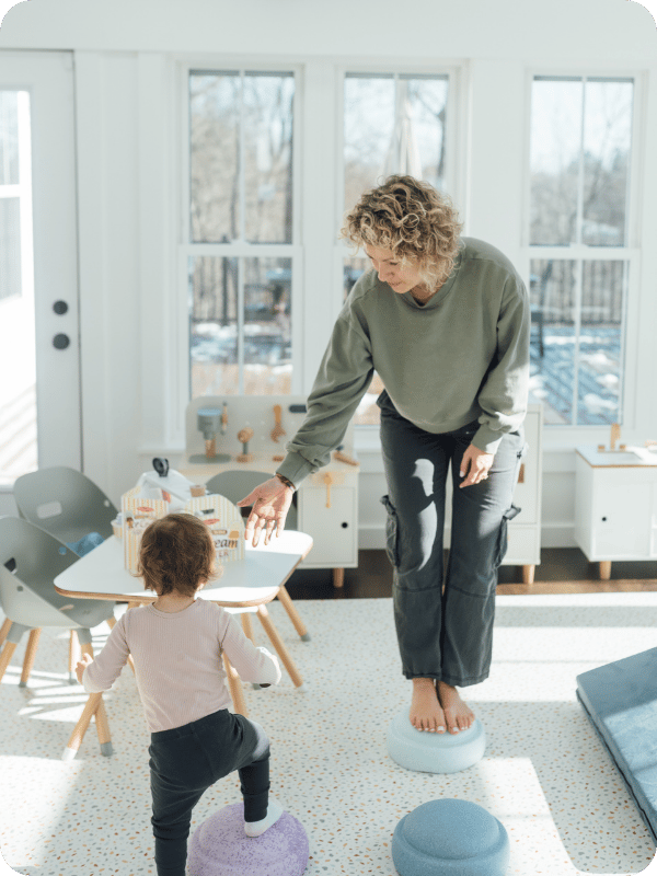 Mom and toddler play with stepping stone toys.