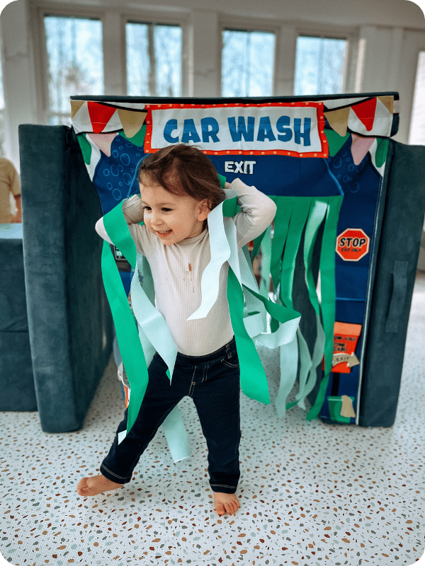 toddler playing in a playhouse made with play foam couch cushions