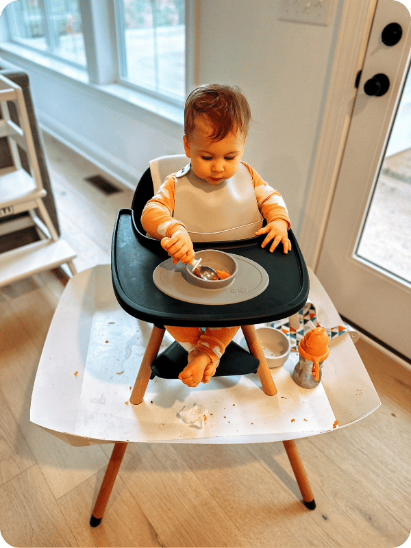 baby using Catchy Food Catcher tray on high chair while eating solids 