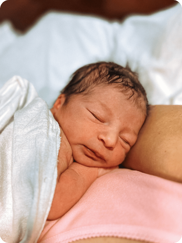 Newborn sleeps on mom