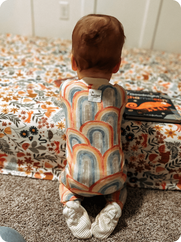 baby in Burt's Bees cotton sleeper pajamas in rainbow print 