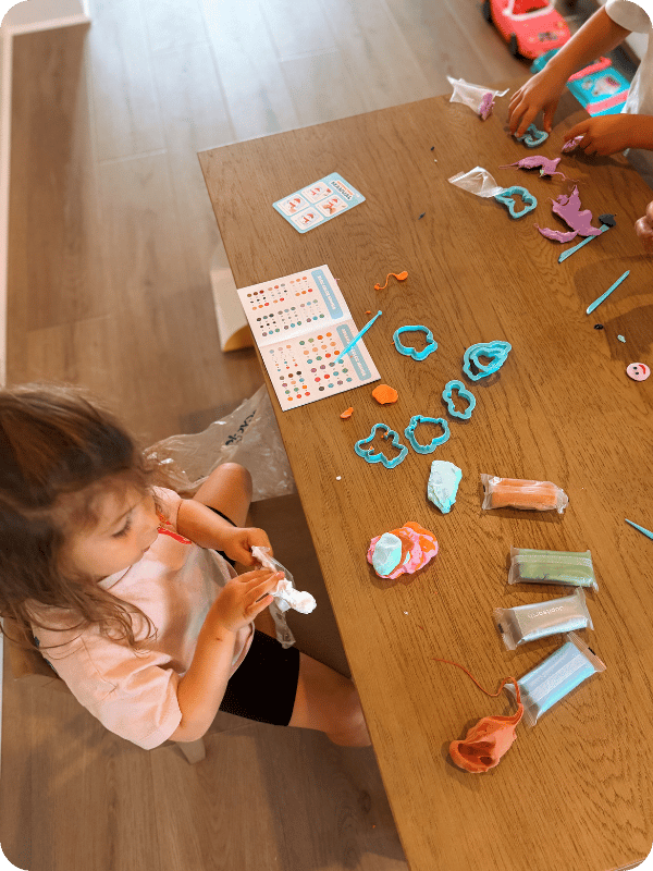 children playing with modeling clay at a table