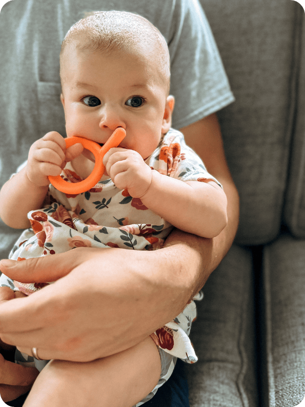 baby chewing on a teething toy